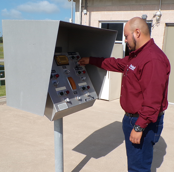 Sharyland Water Supply Corporation employee operating a control panel outside a facility